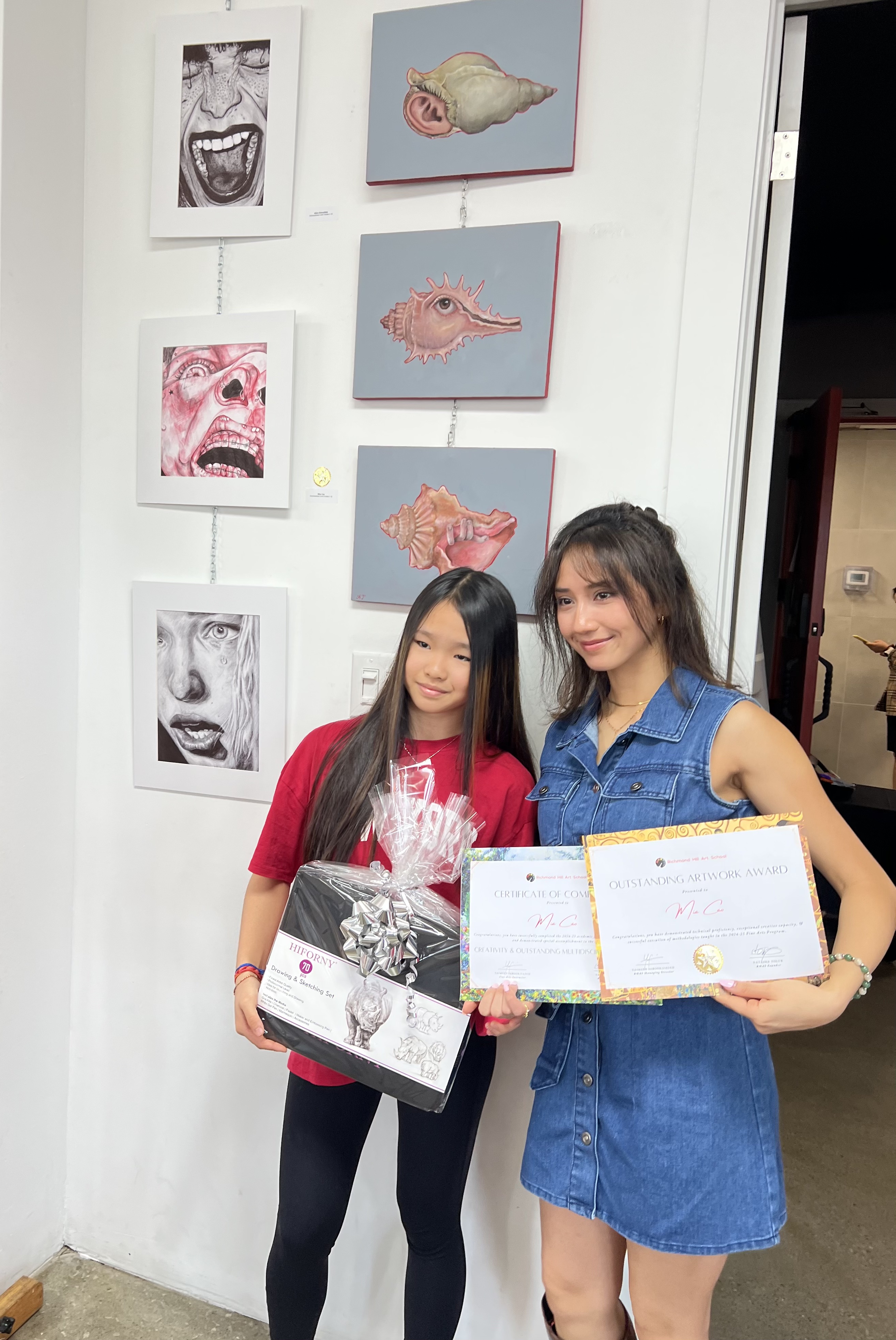 Mia holding an outstanding artwork award and certificate of completion