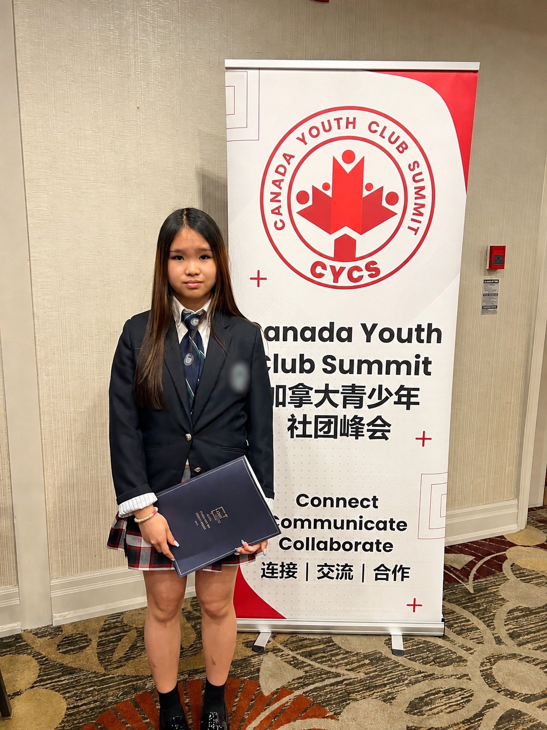 Mia at the Canada Youth Club Summit, holding a folder