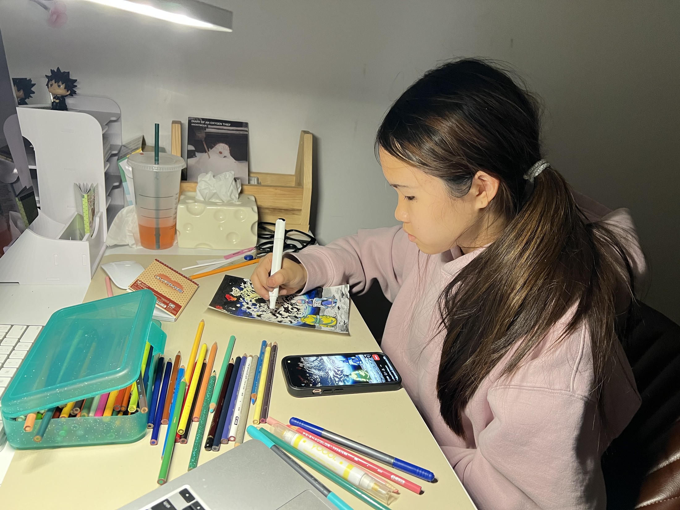 Mia drawing at her desk with colored pencils