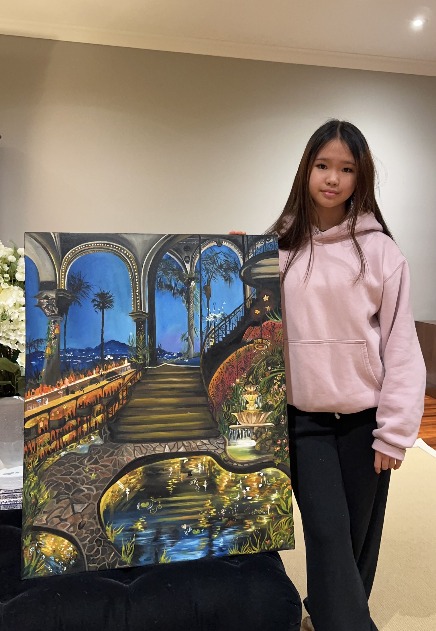 Mia holding her painting Secret Garden of Dreams