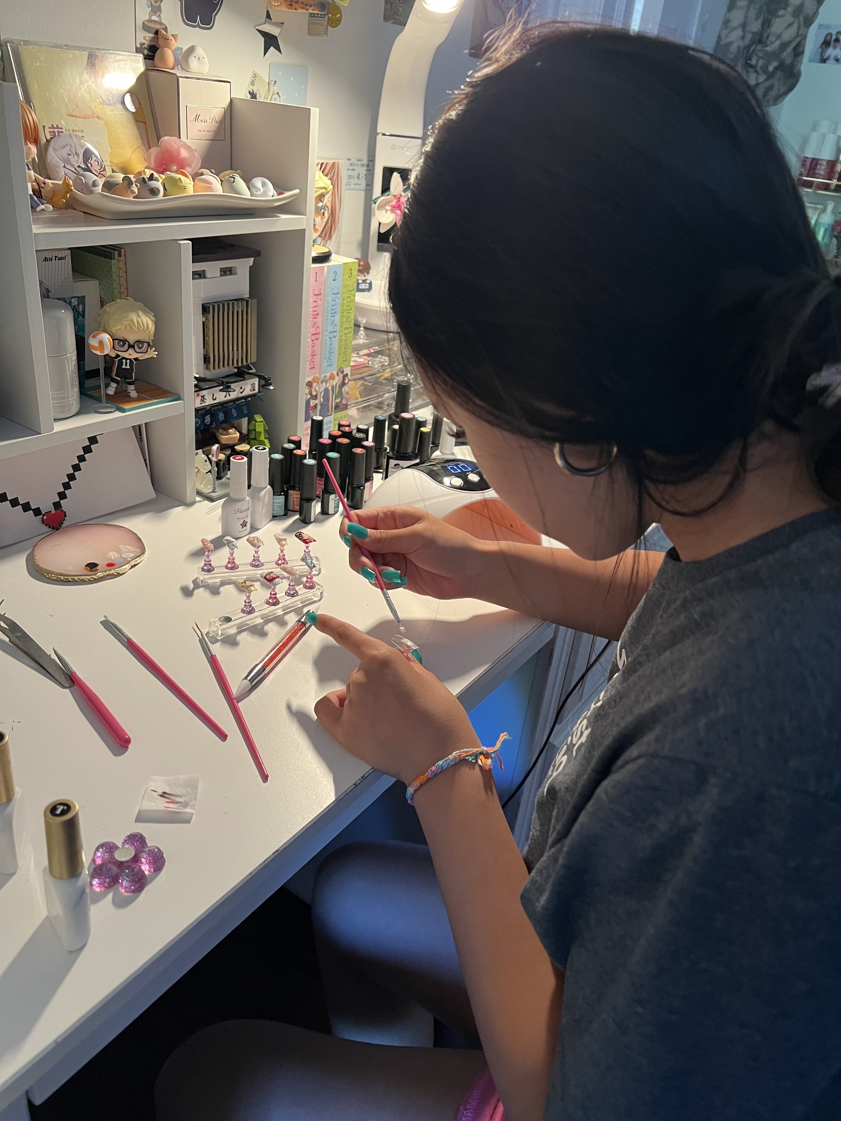 Mia working on nail art and jewelry crafts at her desk
