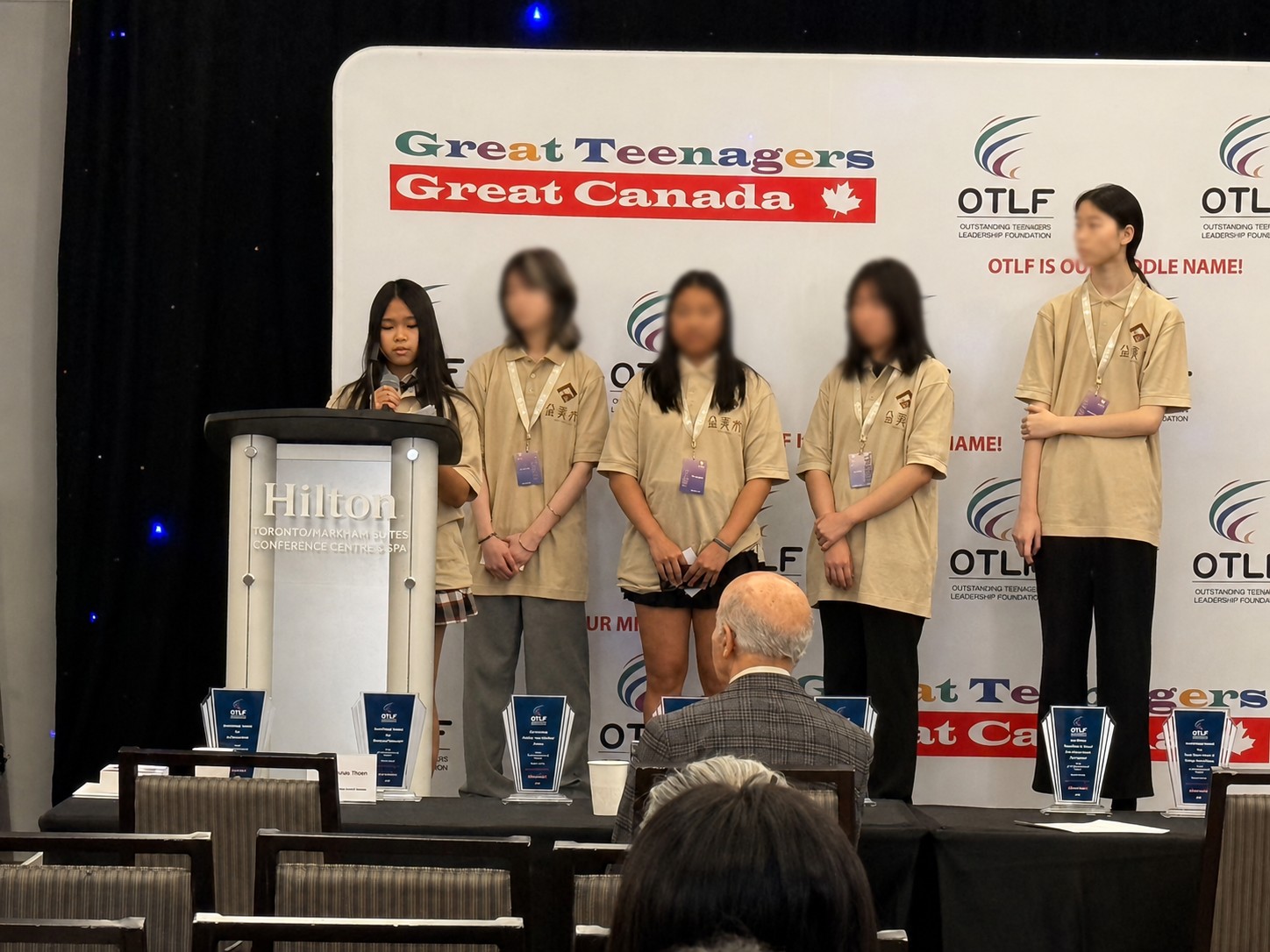 Mia and other teen delegates on stage at an OTLF Great Teenagers Great Canada event