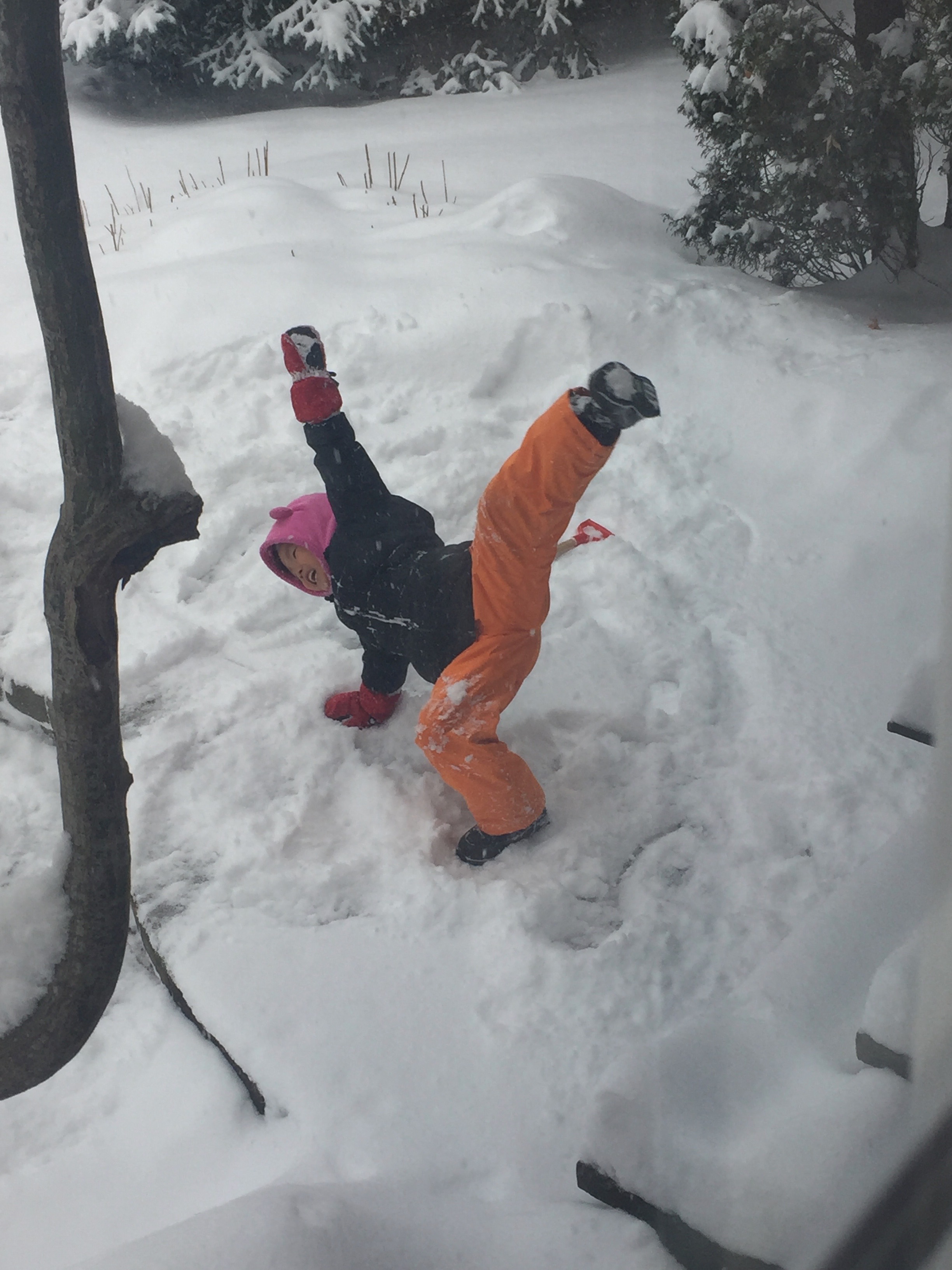 A young Mia doing a cartwheel in a snowy backyard