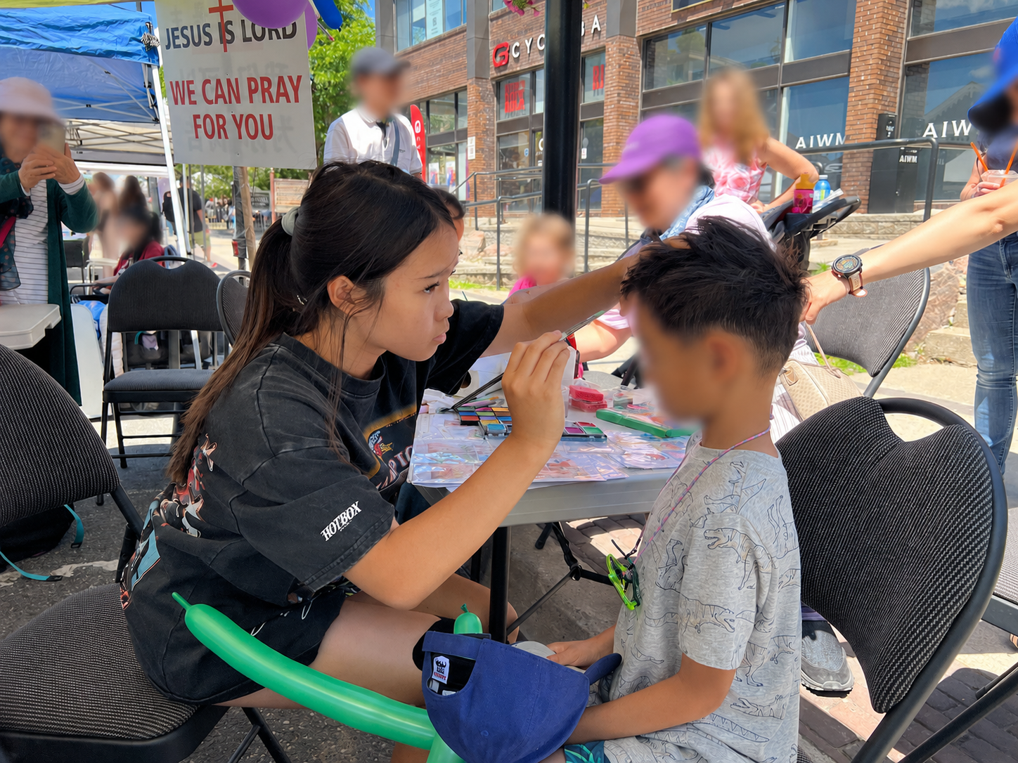 Mia face-painting at a community street fair