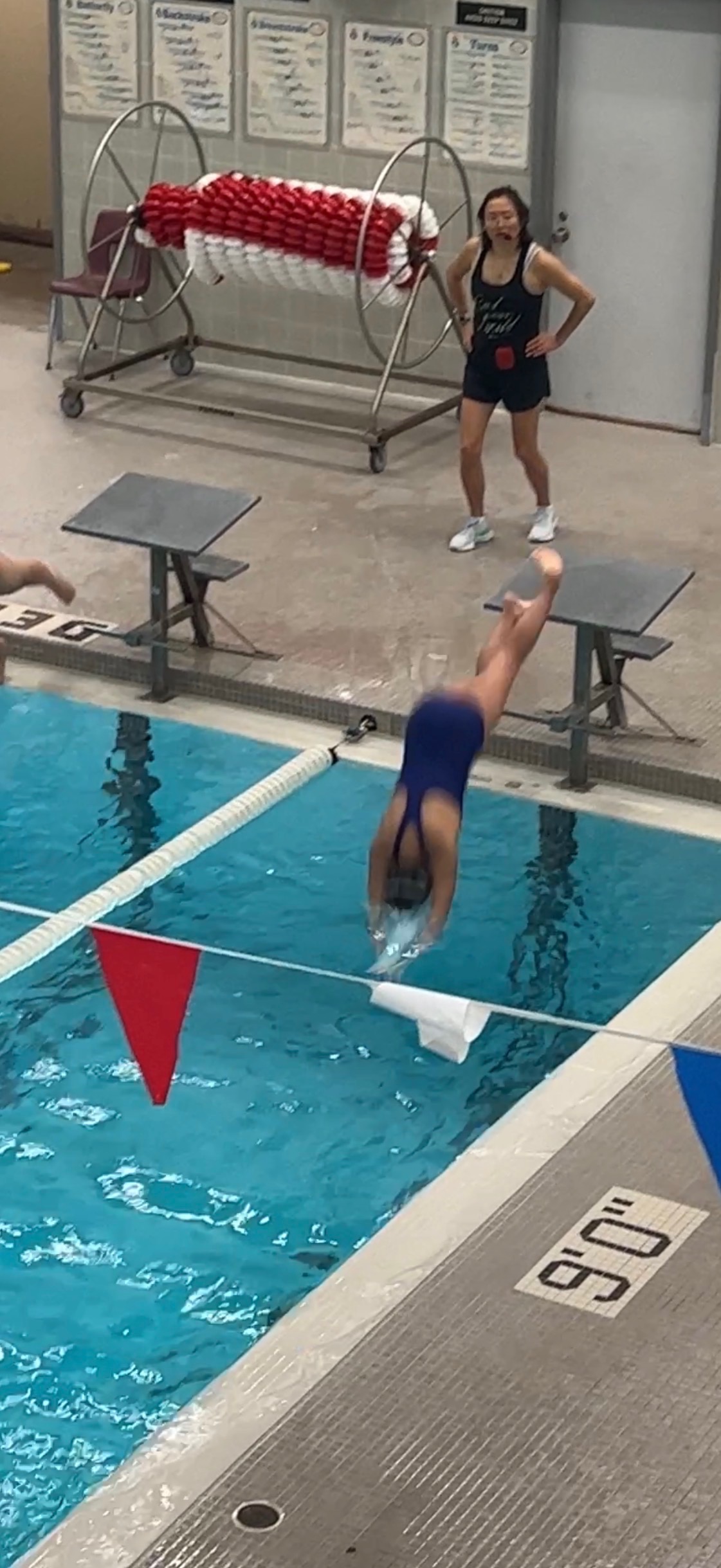 Mia diving off the starting block at swim practice