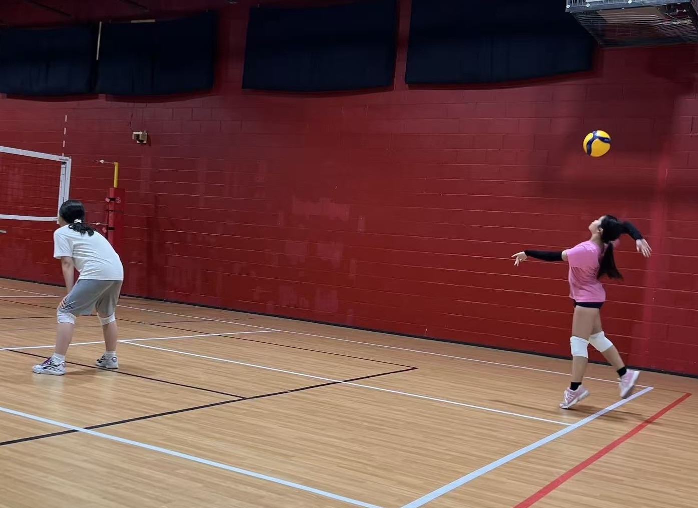 Mia jumping to serve during a volleyball game