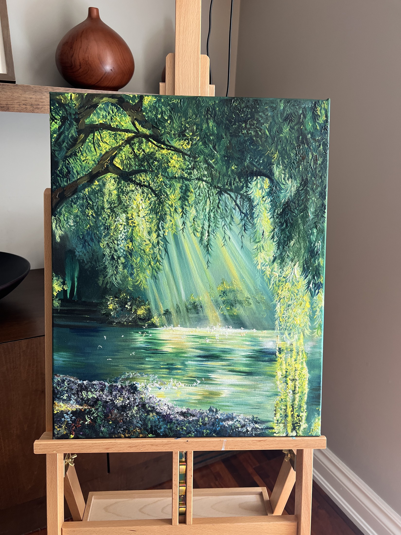 An oil painting of a willow tree with sunlight streaming over a lake